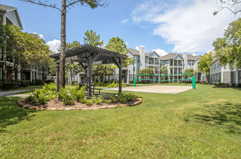 A tree-lined walkway leads to a building